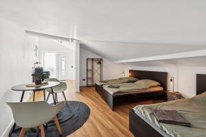 a bedroom with two beds and a table at Nordbrise by BohnApartments - Parkplätze - WLAN - Garten - ruhig in Diepholz