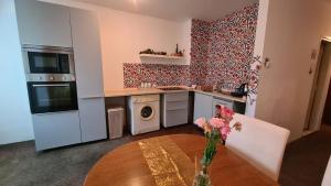 a kitchen with a vase of flowers on a table at Lovely apartment near NS Fair in Novi Sad +11 photos
