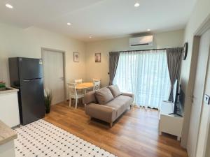 a living room with a couch and a table at The Title Halo1 2BD by MILL in Phuket