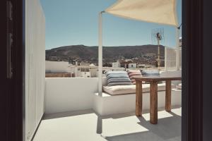 a balcony with a table and a view of a city at Retreat Paros, Fisherman's House, The Hook Apartment in Parikia