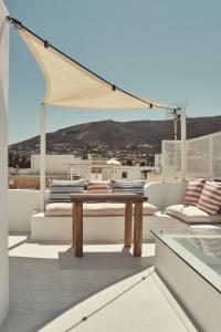 a patio with a table and chairs on a roof at Retreat Paros, Fisherman's House, The Hook Apartment in Parikia