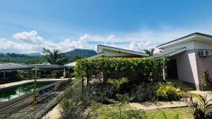 a house with a garden and a swimming pool at Capital O 91186 Rumah Rehat Bukit Inas 