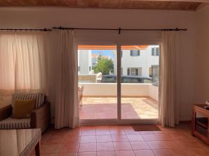 a living room with a sliding glass door to a patio at Sa TORRE 3 by SOM Menorca in Fornells
