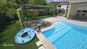 a swimming pool with a blue inflatable at Villa Marea in Opatija