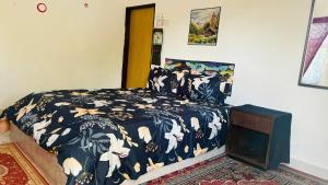 a bedroom with a bed with a black and white comforter at Capital O 91186 Rumah Rehat Bukit Inas  +55 photos