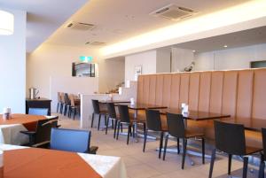 a dining room with wooden tables and chairs at SAIDAIJI GRAND HOTEL - Vacation STAY 92827 in Okayama +1 photo