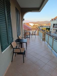 a balcony with tables and chairs on a building at Blessed guest house in Shkodër