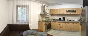 a kitchen with wooden cabinets and a counter top at VSD Apartment in Predeal