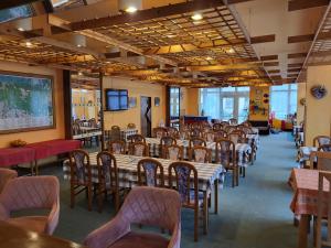 ein Speisesaal mit Tischen und Stühlen und ein Klassenzimmer in der Unterkunft Hotel Nico in Špindlerův Mlýn