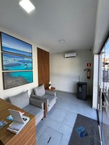 a living room with a couch and a table at pousada praia bela japaratinga in Japaratinga
