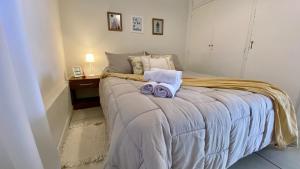 una camera da letto con un letto con due asciugamani sopra di Aloha Teo - Departamento por Día en Trelew, espacioso y cerca de todo! a Trelew
