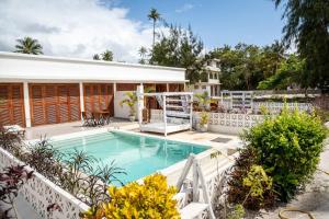 a swimming pool in front of a house at ZAN Orient Beach Hotel in Bwejuu