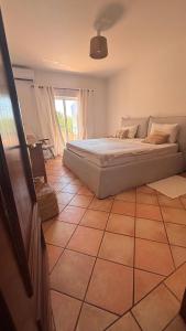 a bedroom with a bed and a tiled floor at NEW! Casa do Praia Almancil in Almancil
