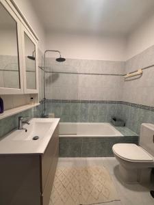 a bathroom with a tub and a toilet and a sink at NEW! Casa do Praia Almancil in Almancil +11 photos