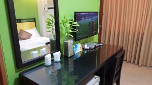 a room with a desk with a television and a bedroom at Residencia Boracay in Boracay