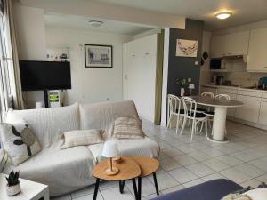 a living room with a couch and a table at Sand Rose Studio in Koksijde