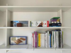 a book shelf filled with books and other books at Sand Rose Studio in Koksijde
