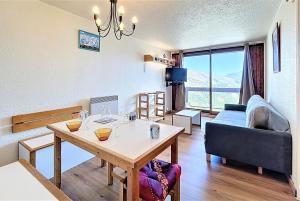 a living room with a table and a couch at travelski home classic - Résidence Phénix in Le Corbier