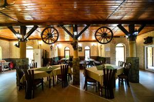 a dining room with tables and chairs and wooden ceilings at Complex Magiyata na Rila in Rilski Manastir