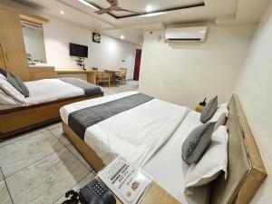 a hotel room with two beds and a television at Hotel Polovictory Inn in Jāmb