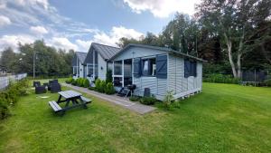 a blue house with a picnic table in a yard at Domki SILVER 3 in Jarosławiec