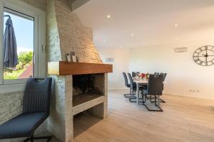 un salon avec une cheminée et une table avec des chaises dans l'établissement Canelli - Magnifique Vue Mer, à Pietrosella