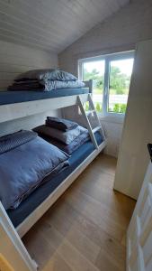 two bunk beds in a room with a window at Domki SILVER 3 in Jarosławiec