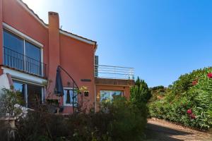 une maison sur une colline avec des fleurs devant elle dans l'établissement Canelli - Magnifique Vue Mer, à Pietrosella