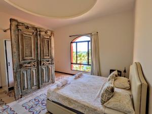 a bedroom with a large bed and a window at Super Central Somabay 2BR Marina Apt w Free Beach in Hurghada