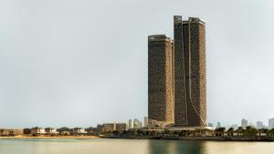a view of two tall buildings next to a body of water at Rosewood Doha in Doha