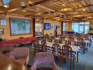 Ein Raum mit Reihen von Tischen und Stühlen und einem großen Bildschirm in der Unterkunft Hotel Nico in Špindlerův Mlýn