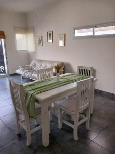 a dining room with a table and chairs and a couch at Chacabuco Aparts in Chacabuco +8 photos