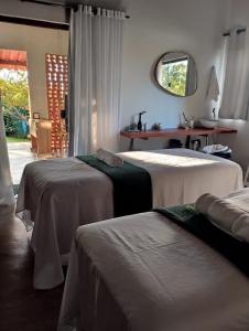 a bedroom with two beds and a mirror and a table at Casa de São Jorge in Pirenópolis