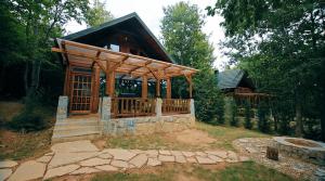 a small cabin with a wooden deck in the woods at Villa n'Mal in Orllan