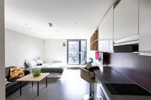 a living room with a bed and a kitchen at New Era Living - Private Rooms next to Bramall Lane in Sheffield