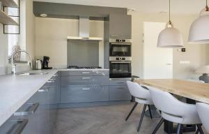 a large kitchen with blue cabinets and white appliances at Z Luxe Villa Bouwlust in De Cocksdorp