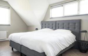 a bedroom with a large bed with white sheets at Z Luxe Villa Bouwlust in De Cocksdorp