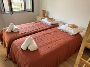 Dos camas en una habitación con toallas encima. en Idéal pour un séjour à Bordeaux, en Blanquefort
