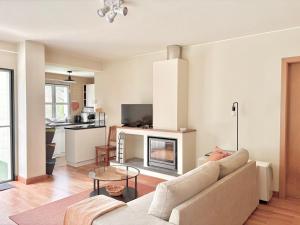 a living room with a couch and a fireplace at Casa dos Netos - Garden & Lake III (Sete Cidades) in Sete Cidades