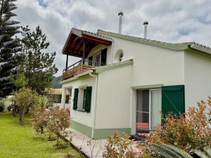 a white house with a balcony on top of it at Casa dos Netos - Garden & Lake III (Sete Cidades) in Sete Cidades