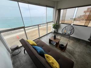a living room with a couch and a view of the beach at mini departamento frente al mar in Punta Hermosa