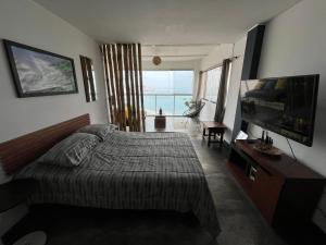 a bedroom with a bed and a flat screen tv at mini departamento frente al mar in Punta Hermosa