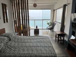 a bedroom with a bed and a view of the ocean at mini departamento frente al mar in Punta Hermosa