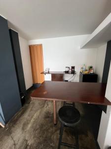 a room with a wooden table and a stool at mini departamento frente al mar in Punta Hermosa