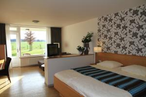 a hotel room with a bed and a television at Hotel Gerardushoeve in Heijenrath