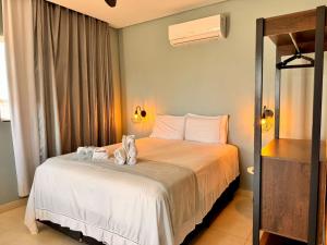 a bedroom with a bed with towels on it at Flat Jade - Alto Paraíso - Chapada dos Veadeiros in Alto Paraíso de Goiás