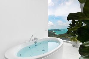 a bath tub in a bathroom with a window at Icon Villa Samui in Nathon Bay +14 photos