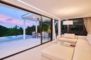 a living room with a couch and a table at Icon Villa Samui in Nathon Bay