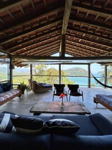 a living room with a couch and chairs and a table at Casa - 3 suítes vista para Barra do Sahy in São Sebastião