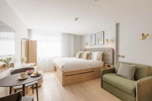 una camera d'albergo con un letto, un divano e un tavolo di Wilde Aparthotels Cambridge City Centre a Cambridge